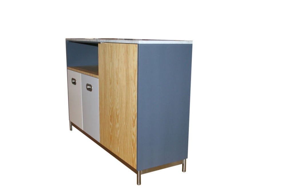 Mn Originals utility island cabinet on solid brushed stainless steel base. Southern Pine Veneer contrasted with matte lacquer colored panels topped with carrara marble top. Blackboard inset surface on one side with Dual pull-out drawers detailed