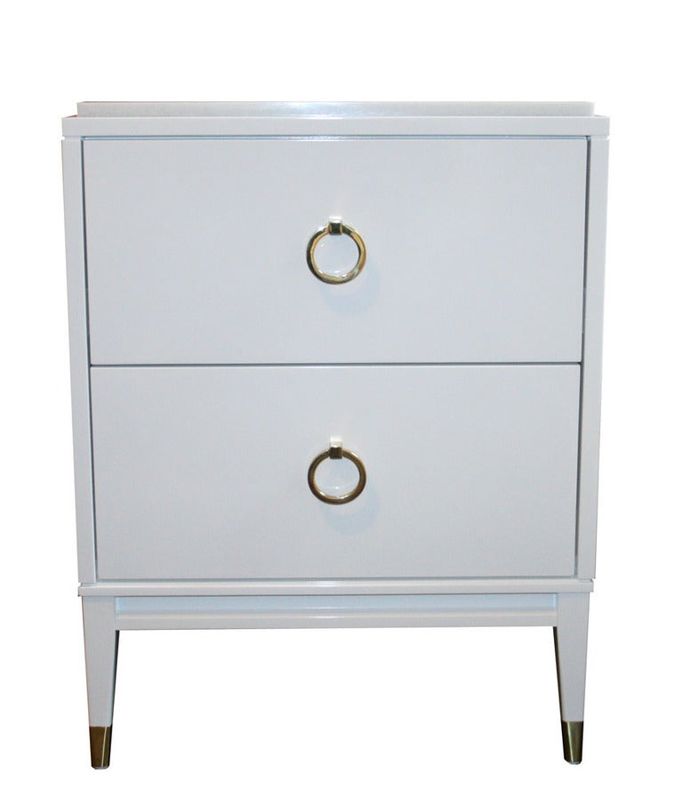 Two-drawer lacquered marble top. Two equal sized drawers are fitted with solid brass ring pulls. Solid apron base with tapered legs that are detailed with polished brass sabots. Top surface is an inset polished marble top.
Sabots shown not included
