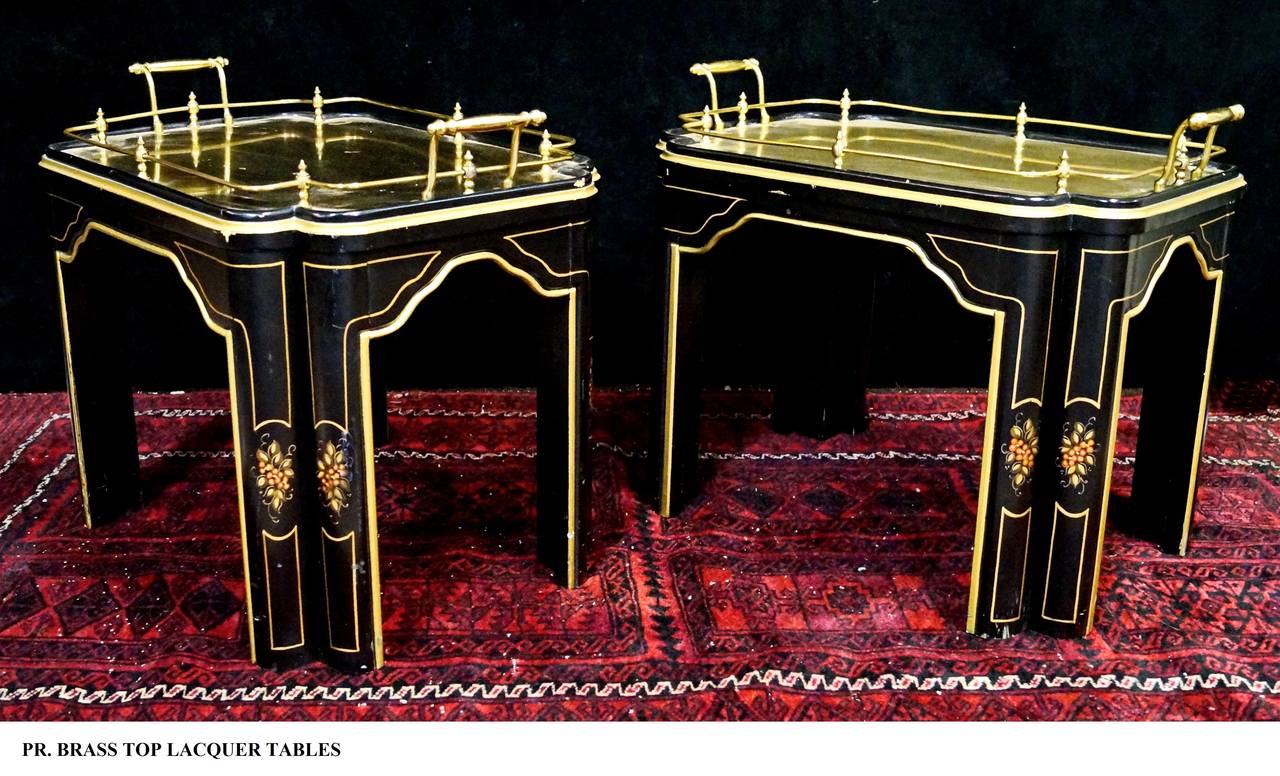 A rare find in these very unusual tray top coffee tables or end tables.
Black lacquer with hand-painted leaves and berries on the legs, note all legs are doubled. Gilt trim on all sides. The tray is solid brass with two handles, screws in to frame