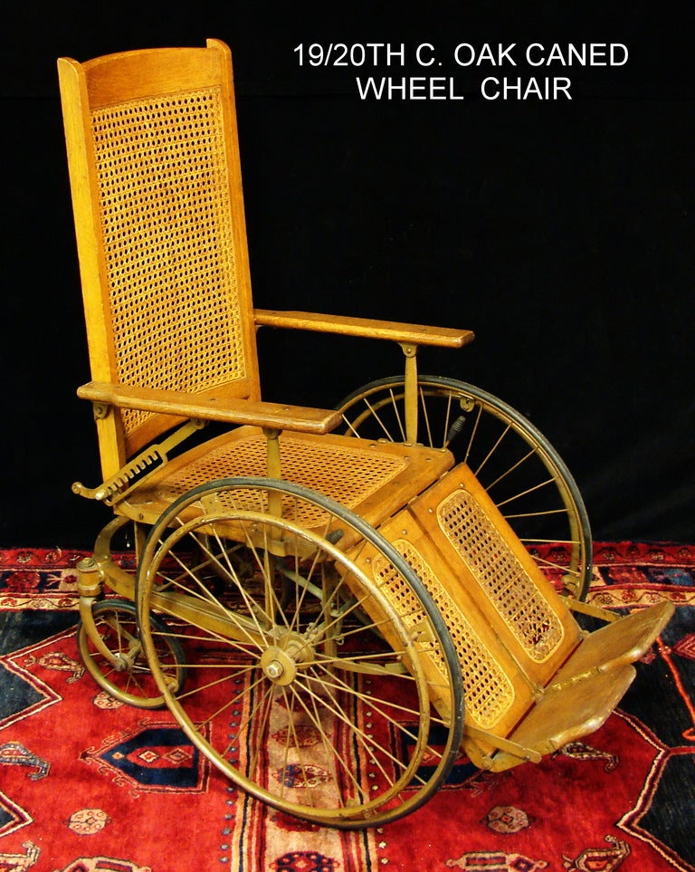 A wonderful 19th century Americana Oak Wood and cane Wheel Chair.Steel wheels front and back,strong cane seat and foot rests,all parts are in excellent working order,great conversation fun piece.