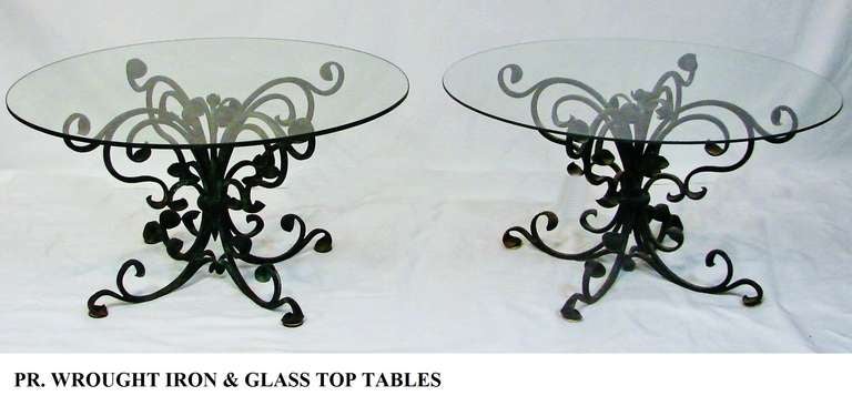 A pair of French Art Nouveau well detailed hand-wrought black iron side or end tables. 
Would also work as a side by side coffee table duo. The glass is 1/4 inch thick.