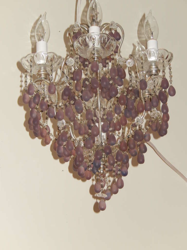 A rare and fine amethyst and crystal chandelier from France. There are seven lights
held in hand-etched crystal cups, each light goes up to 25 watts. There are six lights around the top and one sits in the middle of the chandelier. Metal arms at