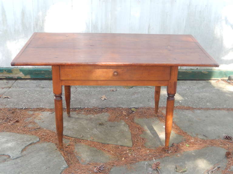 A one drawer early 19th century pine wood desk/table. Original iron casters on feet, seats four, good uses would be a desk or dining table.