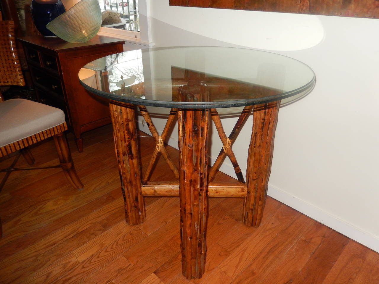 Circular bamboo and Tortoise Shell finish dining room table. Seats four comfortably. With a 40 inch beveled glass top.