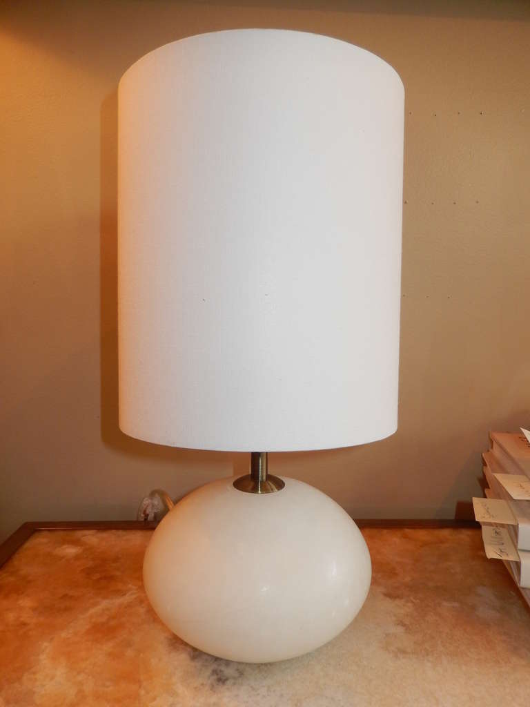 Pair of alabaster table lamps, with white linen drum shades. Nickel rods and ball-shaped finals. New wiring and sockets. Tall drum shades. Although small, these lamps have a good weight, solid alabaster. Slight amber or grey veins run through the