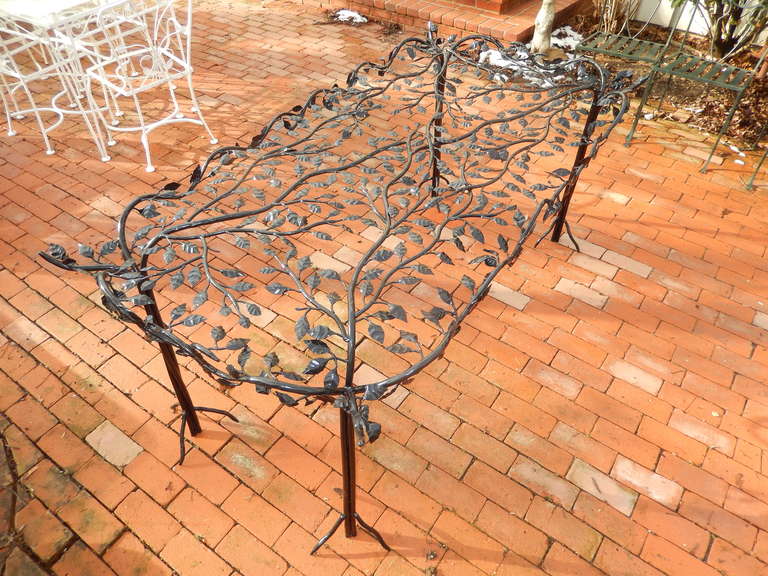 A rare and beautiful hand forged iron table in the school of Giacometti. Over 500 hand forged leaves with vines, reaching out to four uniquely decorated corners. The legs have three strong branch form feet. Shown without the glass,
which is 1/4