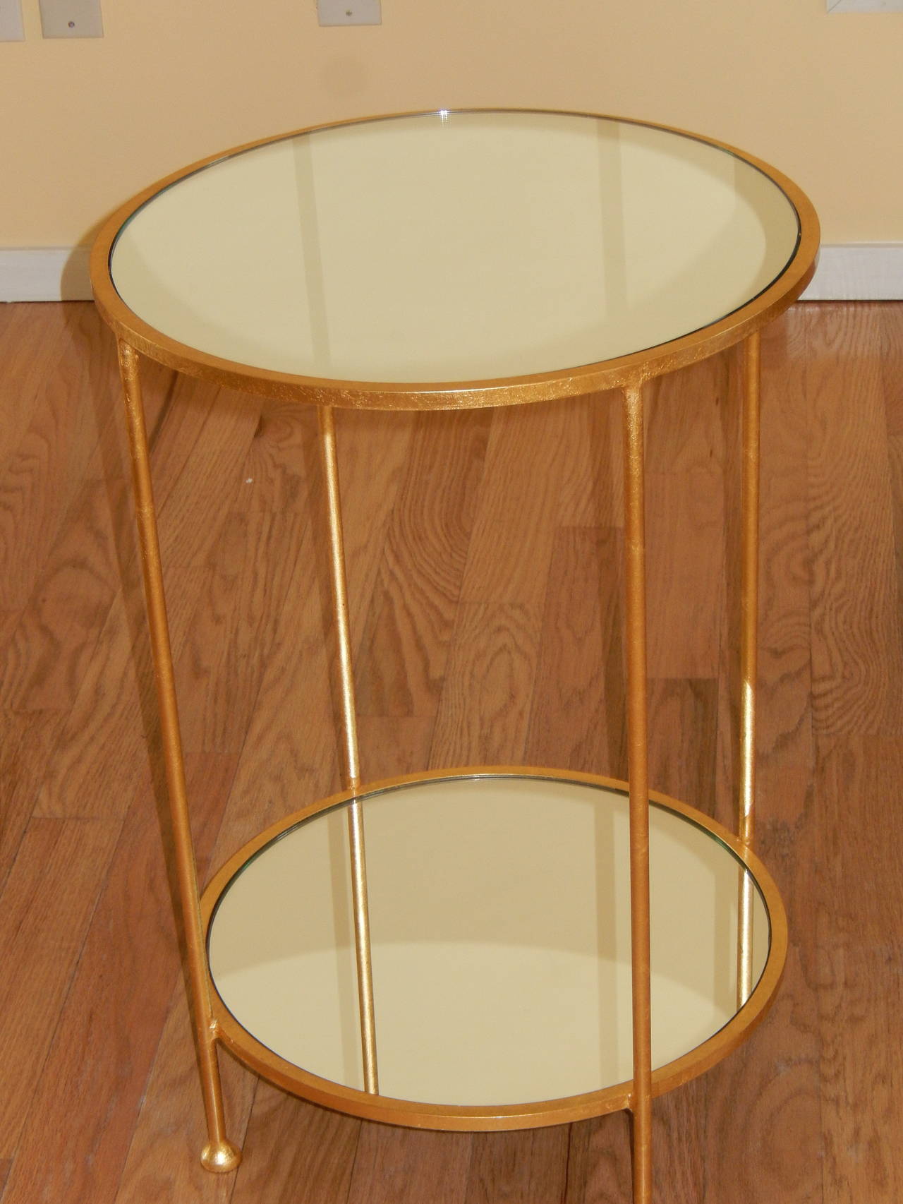 An elegant mirrored two level side table, gilt finish over steel.