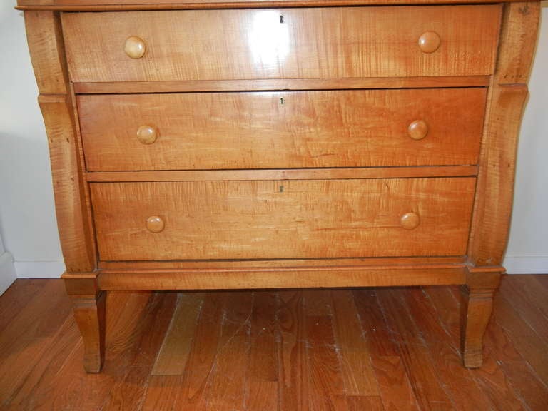 This is a wonderful dresser from the Empire period, made of solid tiger maple woods (not veneers). The top drawer has an inside height of 10 inches (good storage) there are three additional drawers which all taper slightly from the top down. The
