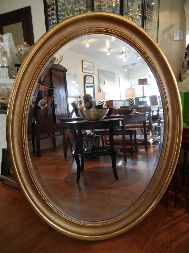 An oversized gilded wood framed mirror with a three dimensional frame and beveled etched glass. Can be hung vertically or horizontally. The height is 55 inches and the width 42 inches. Please check other images for close up quality.
