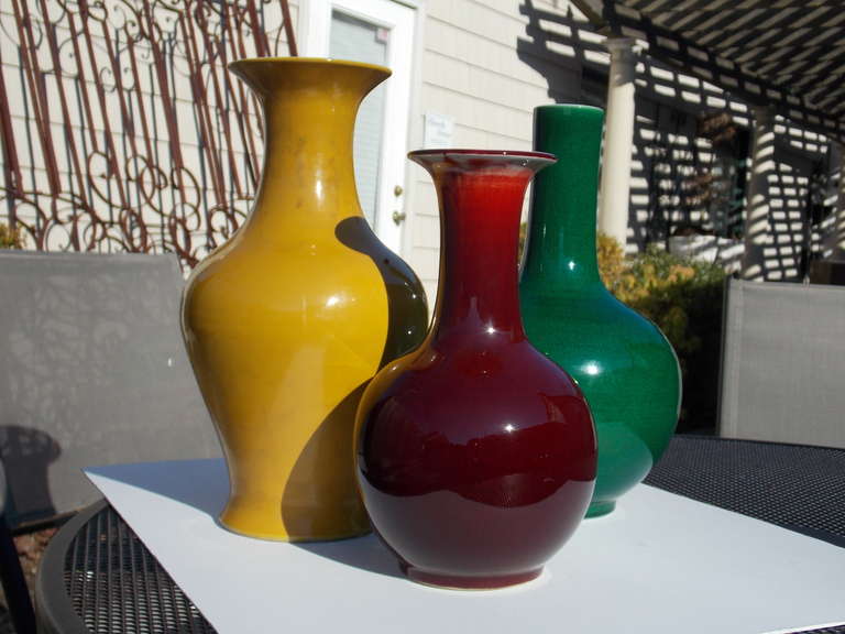 Yellow, oxblood and emerald green make for a striking presentation in these three Chinese Peking Glass Vases. The yellow and emerald green each measure 11.5 inches tall while the oxblood measures 9.5 inches tall. All in lovely condition and dating
