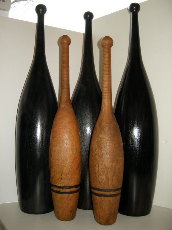 Decorative group of early and later sculptural wooden clubs.The two smaller one's are from the late 1800s,and of light mahogany woods,the three tall pins are all with an ebony finish,from around the 30s.