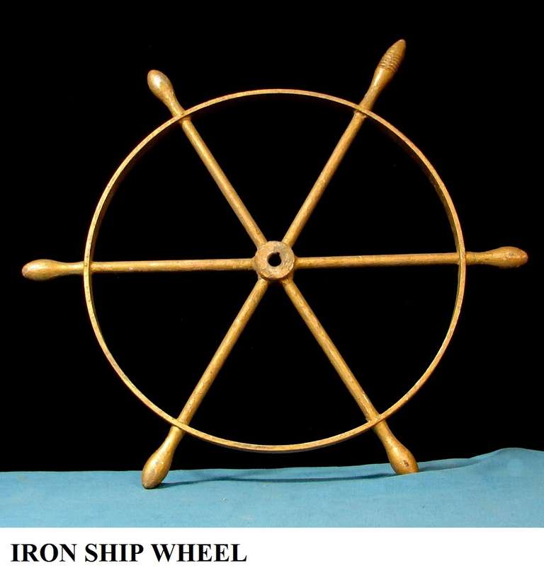 An antique iron ship wheel. In a gold antique finish, great wall decoration or door mount.