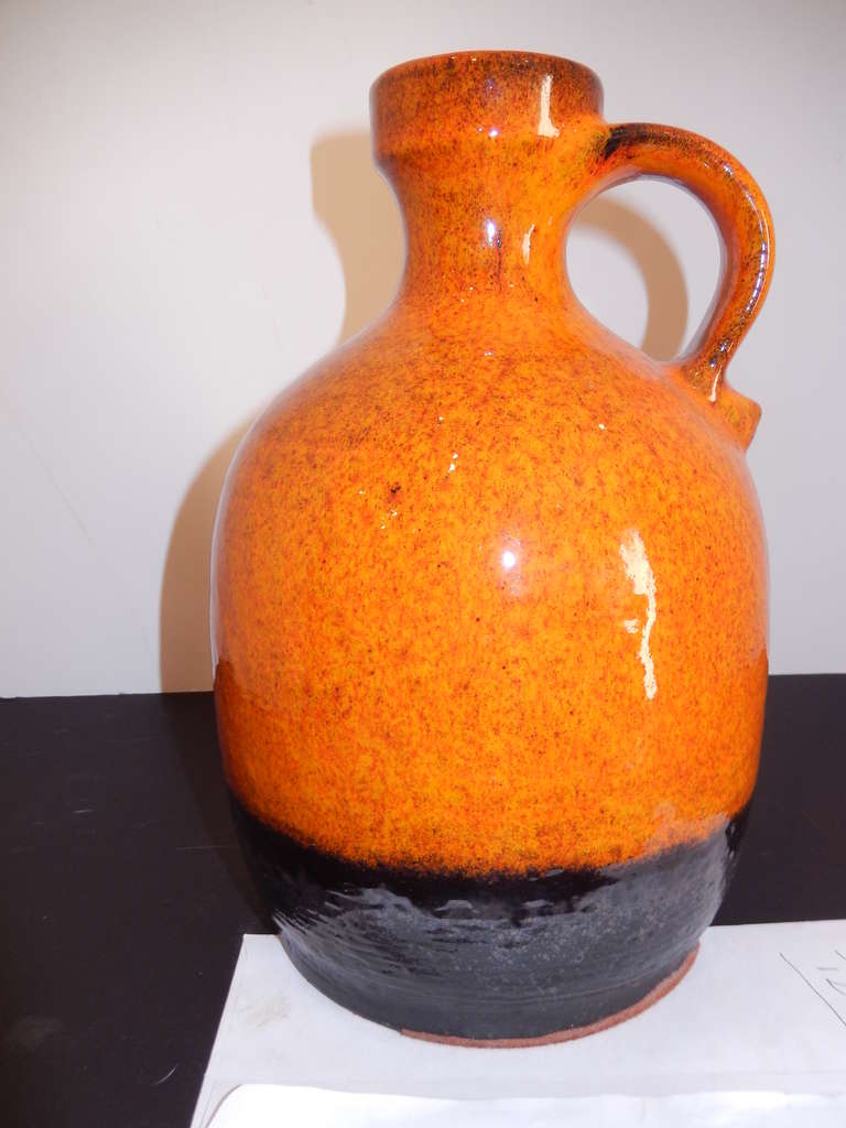 A studio pottery vase (Germany) about 1960s. Exciting fiery colors in deep double glazed orange and chocolate brown. One large handle.