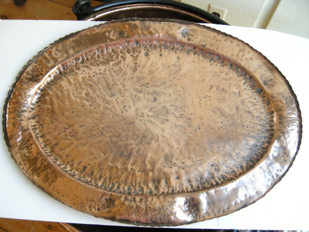 A large oval shaped Arts & Crafts hand hammered copper tray.Beautiful original patina,with hammered relief around the diameter,a wonderful serving vessel or drink tray,great center piece.Purchased from an estate sale in Devon England this year,check