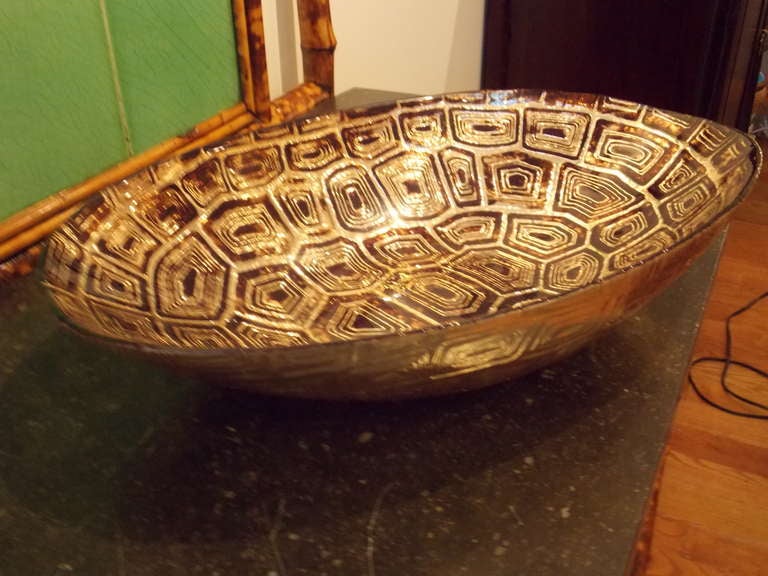 A large 1970's Italian glass bowl with a turtle shell patterned top.
Rich shades of gold and chocolate brown, with hand-etched relief
The bottom is silvered, makes a stunning center piece.