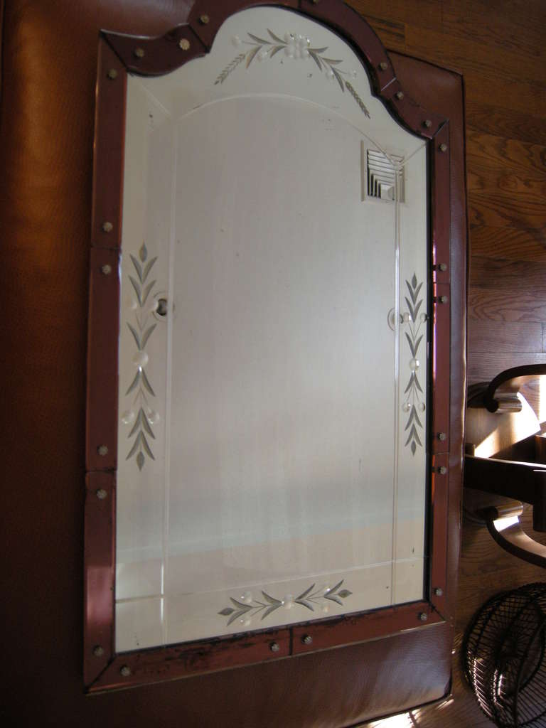 A magnificent French Art Deco wall mirror. The outer frame in a rich wine red tinted glass, the mirror showing hand etched wheat decoratives on all sides, an unusual piece of French Art Deco.