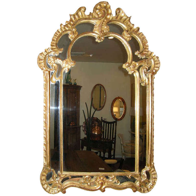 A lovely Rococo, gesso wall mirror with the original gilt over green finish, showing some loss. Lots of good hand-carved details, a Classic beauty.