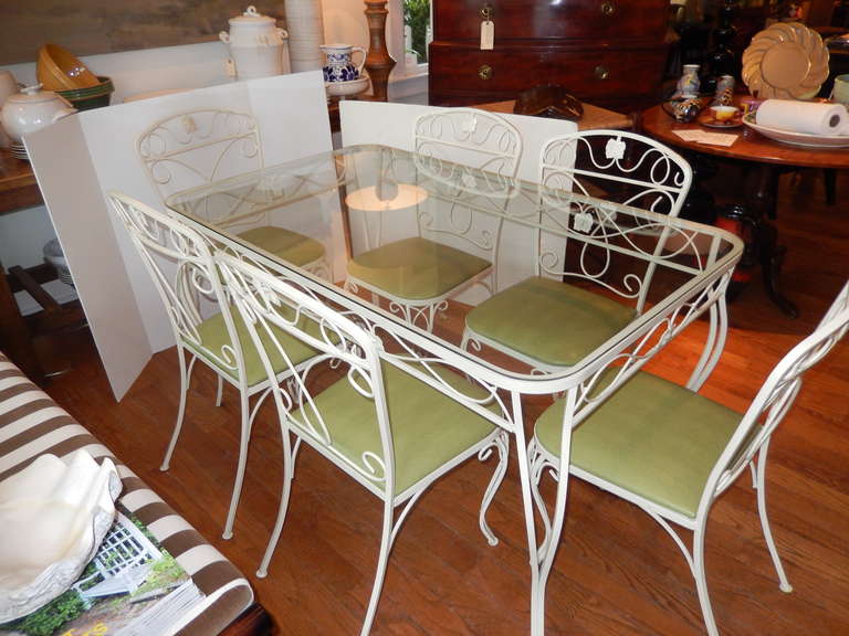 A Salterini Mid-Century group of six chairs and table. Decorated with leaves and vines, new powder coating for outdoor use in a buttermilk cream color. Beautiful condition, all decoratives intact. Measurements listed are for the table. Chairs