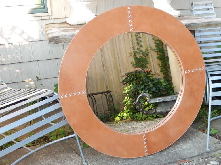 A large circular hand crafted mirror in a beautiful hand stitched tan leather. Diameter listed is of entire mirror; diameter of the glass itself is 24