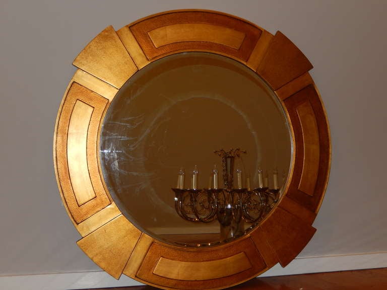 A dramatic and outstanding hand-carved custom Art Deco mirror. The two tone gilded finish helps define each of the cut-out carvings, having all of the classic Art Deco elements.