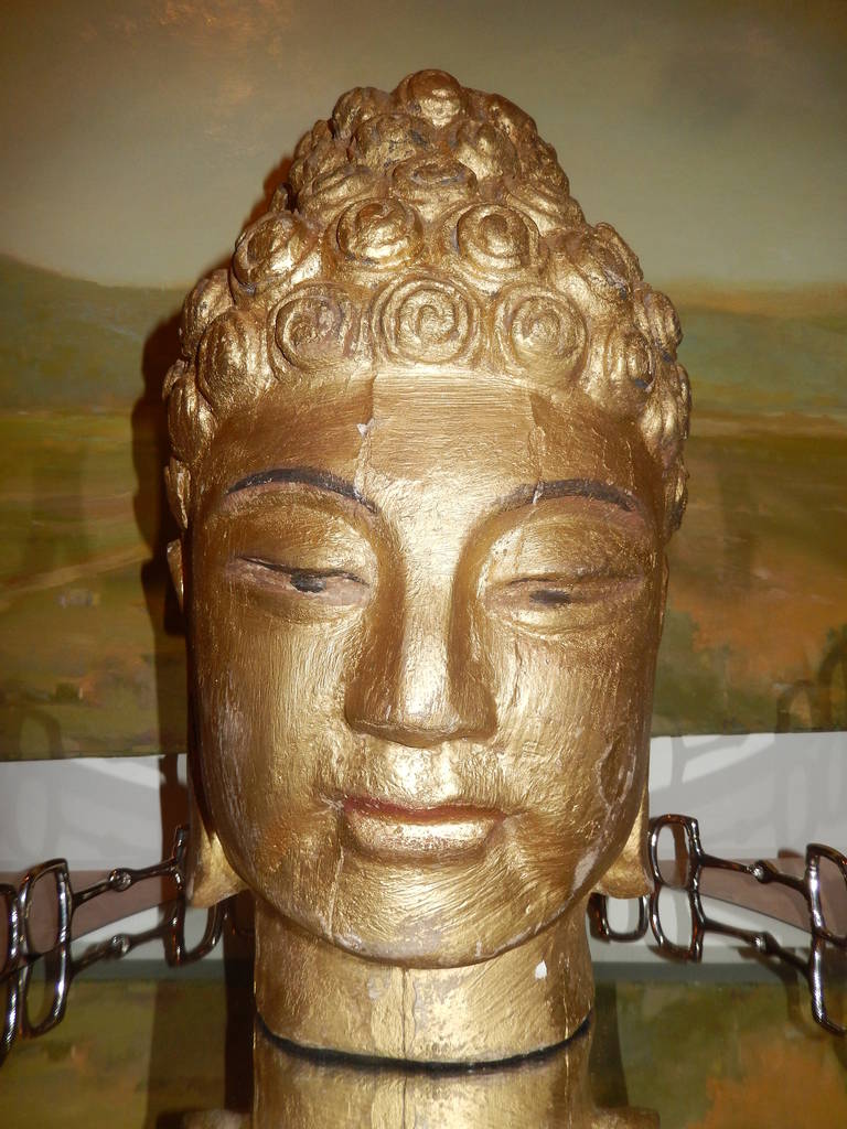 A wonderful carved wooden Buddha head with a  piercing  presence.Original Gilt finish.