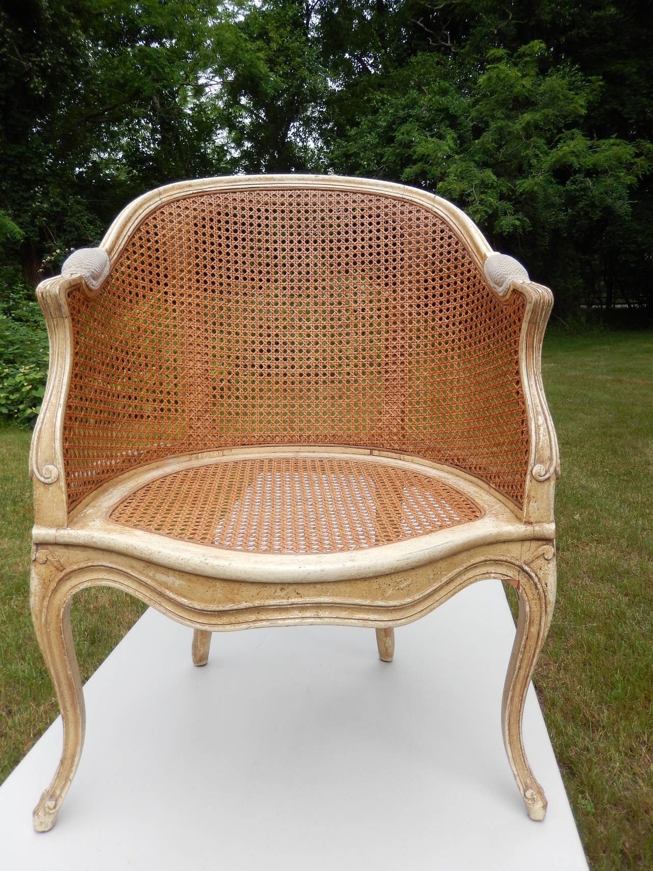Pair of caned bergeres, natural distressed finish, caning in very good condition.
Barrel backs, padded armrests.