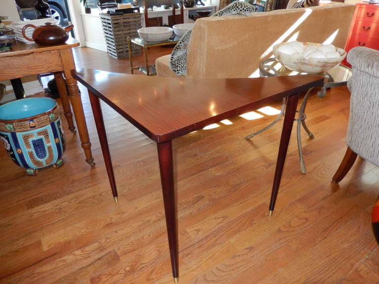 A Scandinavian Mid-Century corner sofa table, with a lacquered mahogany laminate finish, brass tip feet, fits any corner.