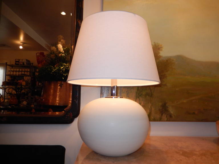 A bulbous form hand-thrown and hand-brushed white ceramic lamp (two available. Chrome cap and rod with a three-way switch, white linen shade, and
glass finial. The lamp measures 18 inches to the top of the shade, 14 inches to the socket, the