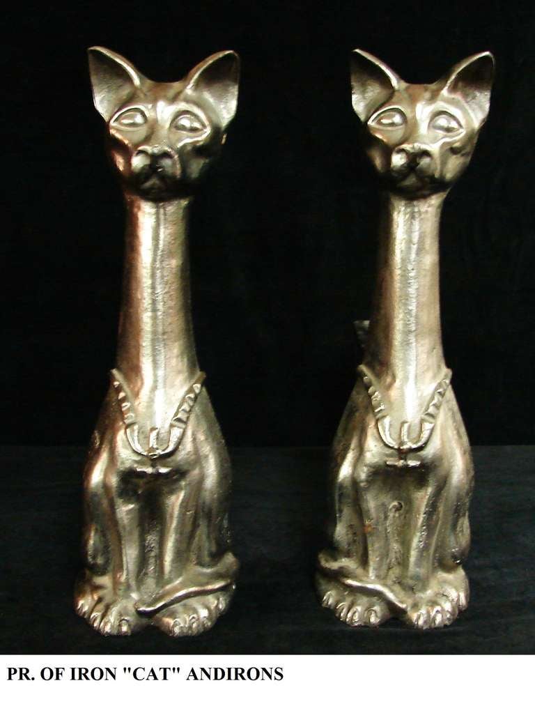 A spectacular pair of Art Deco cat form andirons, standing as 
though they are guarding the ancient tombs of Egypt, with a wonderful pewter tone finish, good details on their faces and feet and wearing an unusual chain or necklace.
Note: They are