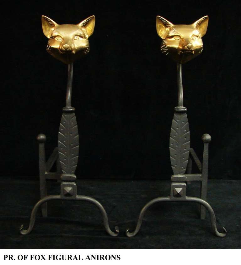 Pair of Art Deco English brass fox head andirons. Well detailed faces and black wrought iron stands.