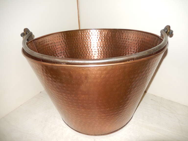 Hammered copper English bucket with steel handle, good for logs, magazines or plants. The shape narrows nicely at the base.