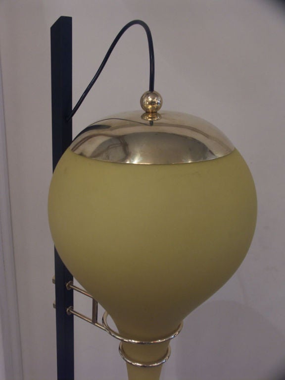 Very much in line with the style and construction of Stilnovo designs. Heavy cast iron railroad style base supports the slender pole. Polished brass hardware with a pair of concentric rings holds the elongated and severely tapered bulbous yellow