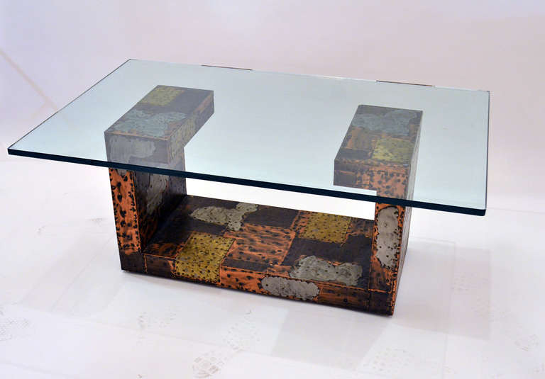 A well executed and designed table by Paul Evans. The table is comprised of hammered sheets of mixed metal, copper, tin, steel. The metals are burnished and scratched revealing surface texture.