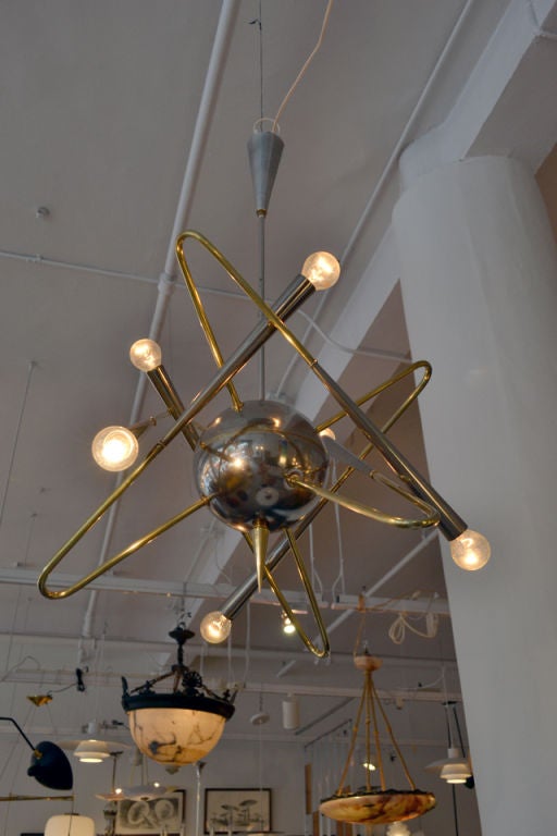 A fantastic chandelier celebrating the atom, attributed to Stilnovo Lighting. The chandelier is comprised of nickel and brass.