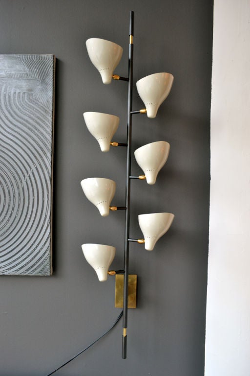 A stunning pair of sconces in the manner of Sarfatti. Each sconce has seven illuminated cream colored cones. An incredibly versatile source of additional task or mood lighting.
