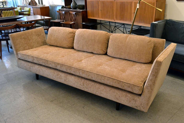 A sophisticated and well dressed sofa by Edward Wormley for Dunbar. The sofa is designed with split open arms and wonderfully carved leg details that extend up the backside.