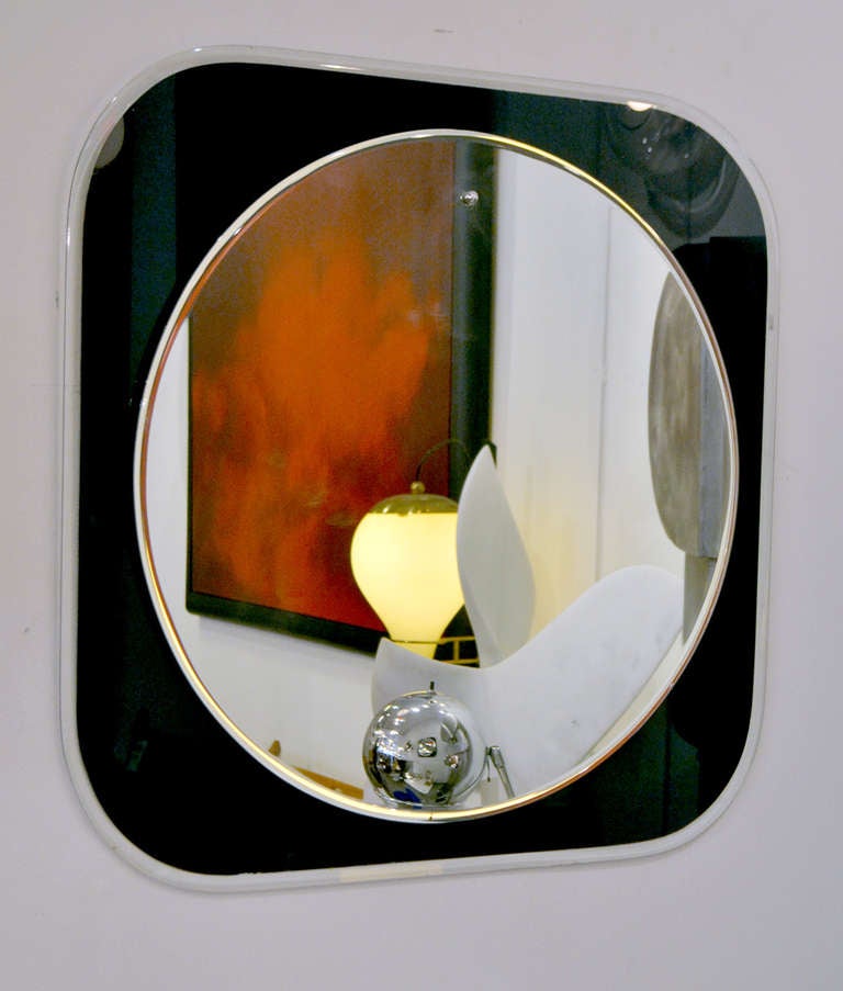 A simple designed wall mirror from 1970's, Italy. The mirror is comprised of a round mirror and back frame made of beveled glass that has been painted black.