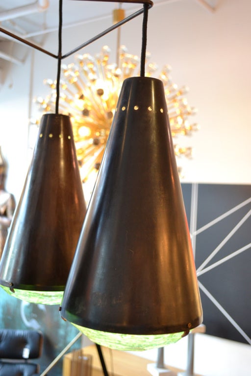 A wonderful multi shade pendant light after a model by Fontana Arte, late 20th-early 21st century.  Each pendant has cut-glass diffuser lenses, housed in an antiqued bronze cone.  An unusual industrial form for that period.