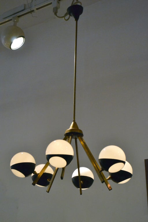 A wonderful six arm chandeleir by Stilnovo, Italy. The chandeleir consists of six glass balls that cradle in metal collars. Each collar articulates in position. A very elegant and playful chandelier.