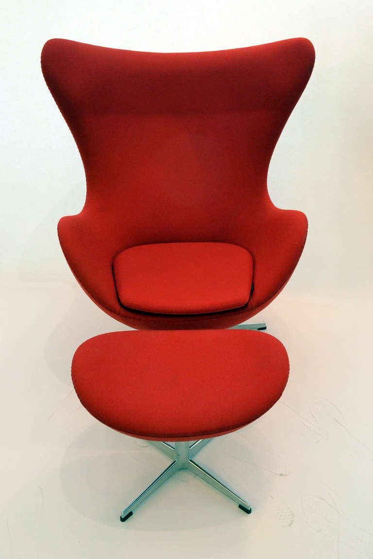 Jacobsen's egg and swan chair designs for the SAS hotel in Copenhagen have become true design icons. This is a lovely matched TiltingbEgg and Ottoman set manufactured by The Republic of Fritz Hansen and upholstered in brilliant red Tonus 2000 wool,
