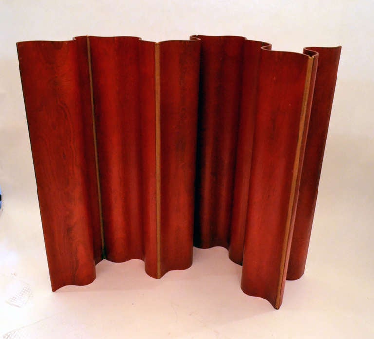 A wonderful red aniline dye folding screen by Charles and Ray Eames. Molded plywood panels with canvas hinges. 