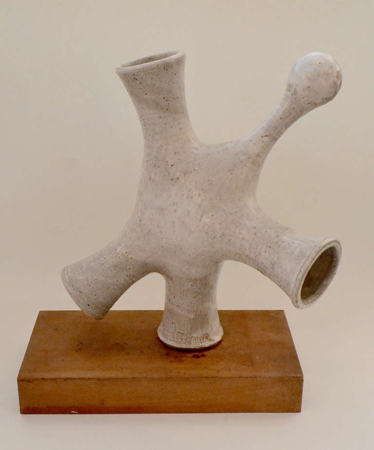 An amorphous stoneware sculpture signed, Beriah. The sculpture is made of funneled cylinders that were made on a potter's wheel and then combined together in an abstract manner. The sculpture rests on a wood plinth.