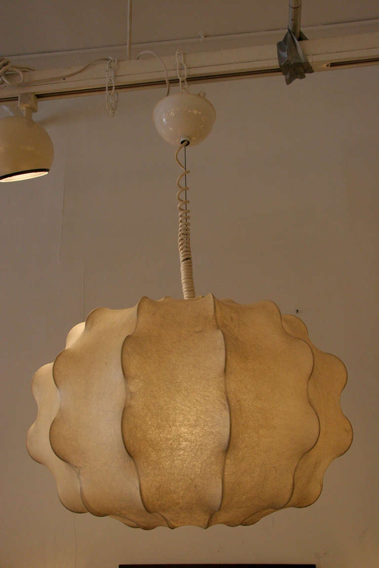 This hanging fixture provides diffused light with a unique resin cocoon and internal steel structure.  The ceiling cap has a mechanism that allows the fixture to be adjusted to a range of heights.