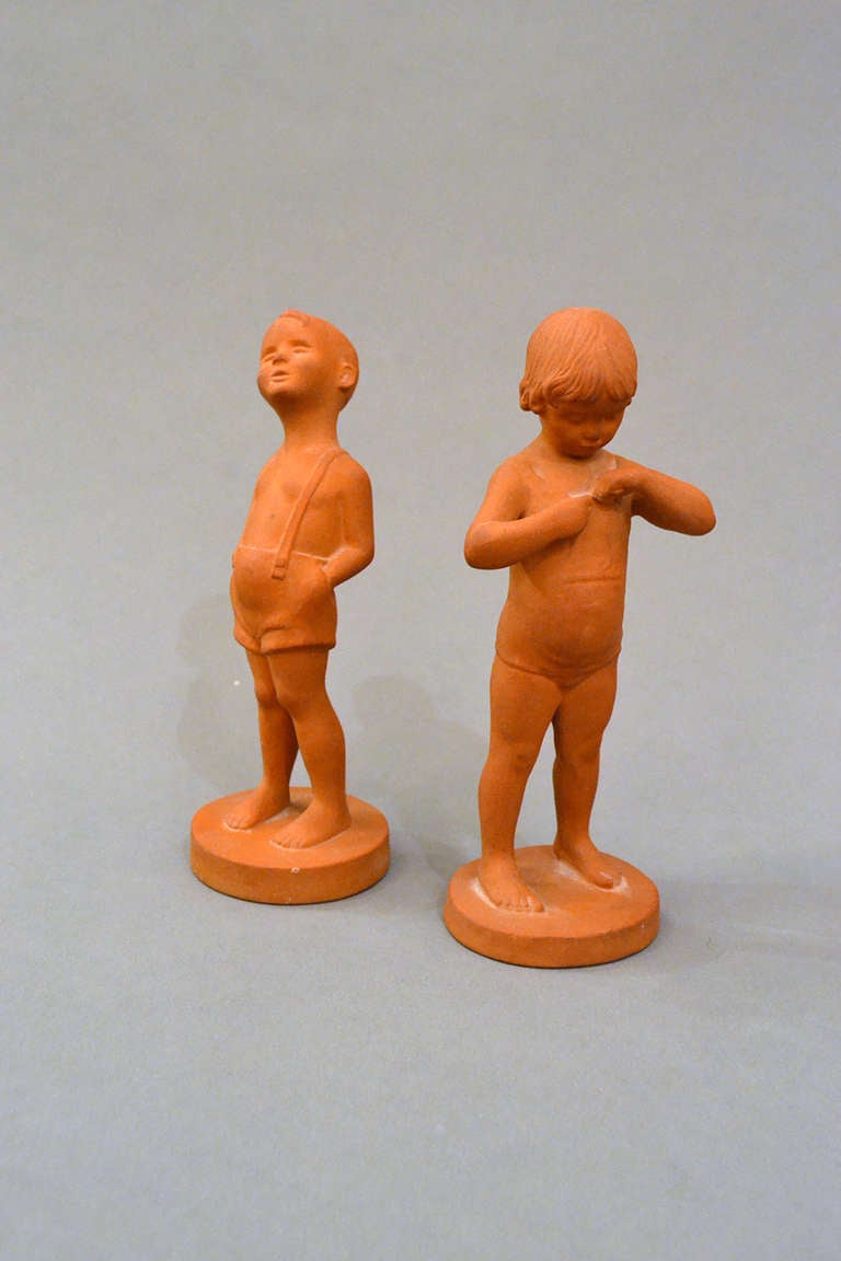 An adorable pair of Danish children figurines in terra cotta. The figures emit a childhood wonder and playfulness; an innocence and carefree air.