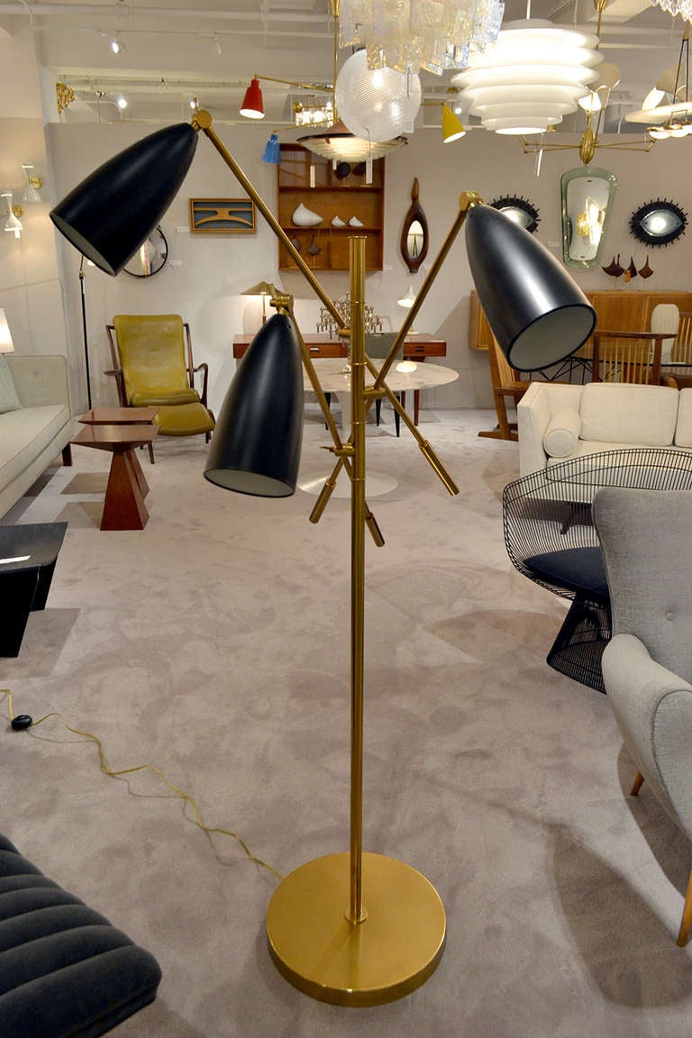 A well designed floor lamp in the manner of the Triennale by Arredoluce, Italy. The lamp is has three bullet shaped shades with brass finished body. A modern must have.