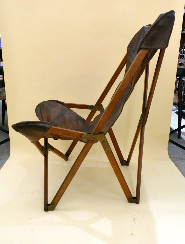 Distressed leather hide folding campaign chair by Joseph Fendy referred to as The Tripolina chair , patented in 1877. Italy.