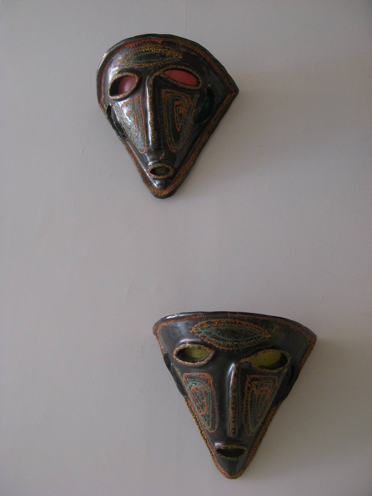 Pair of "Mask" sconces in black glazed ceramic vividly painted in polychrome with colorful translucent shades by Accolay, France, circa 1960.
Signed and numbered on the interior.