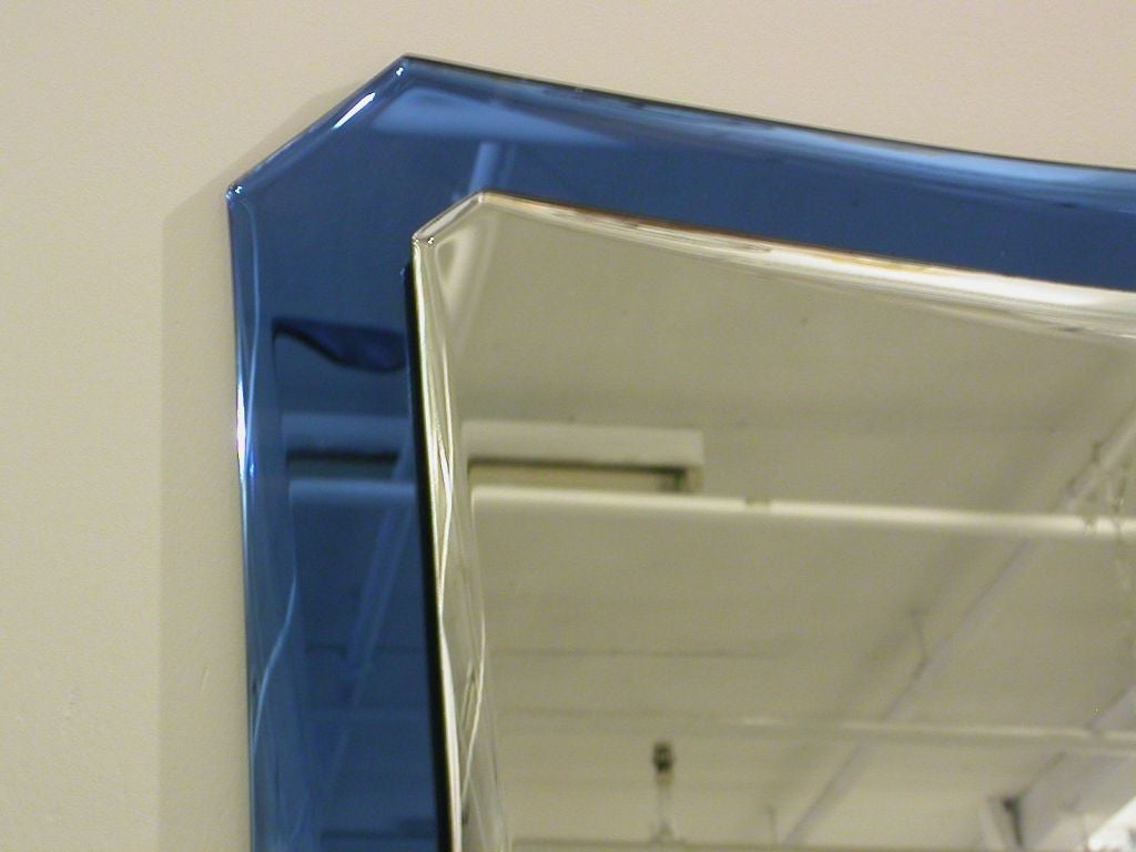 Italian curvy all glass beveled mirror with section in blue glass by Fontana Arte, c. 1960.