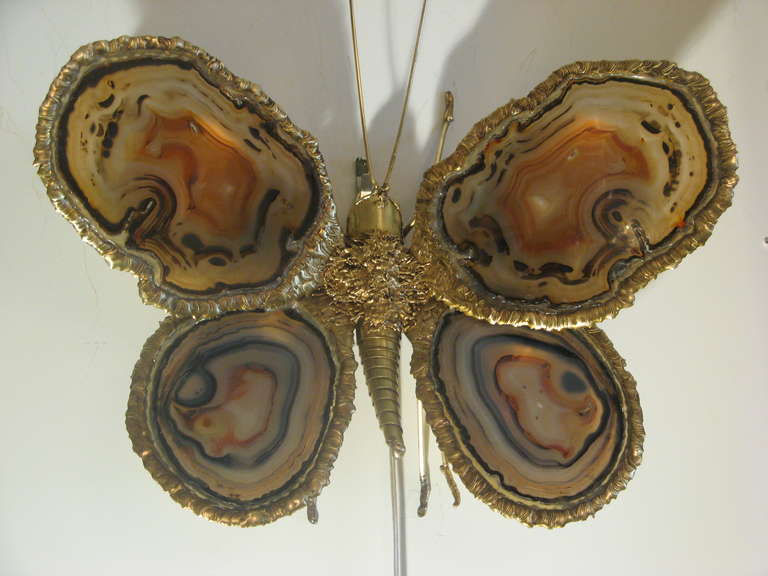 Butterfly sconce in bronze and agate. The wings in blue and brown agate are surrounded by bronze details. When the sconce is lit up, it glows in a golden light.

Designed by Jacques Duval-Brasseur, France, circa 1970.

Newly wired for US with
