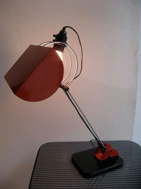 Large Italian adjustable desk lamp with red lacquered metal shade and black lacquered metal base, circa 1970.
